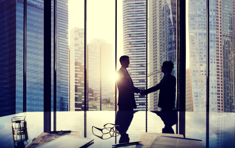 Business men shaking hands at office building