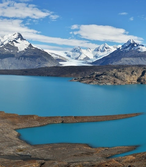 Image of the Andes snow mountains with a blue lake