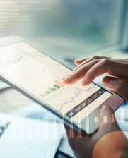 person typing on ipad with stock market