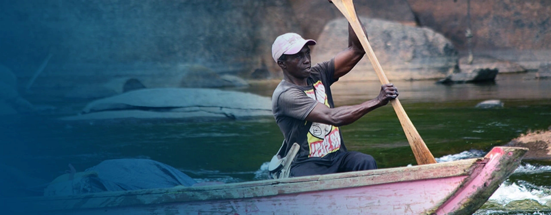 Image of a fisherman sailing on a small canoe