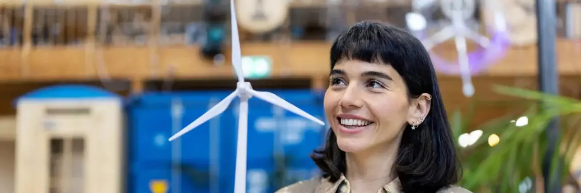 Banner image showin a woman holding a wind power mill