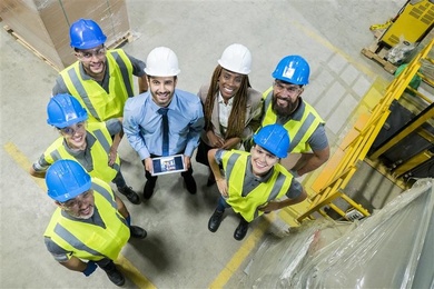 Grupo de seis trabajadores en una planta industrial en América Latina, colaborando en un entorno productivo.