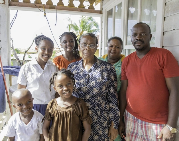Banner image of a family from Trinidad & Tobago at their house.