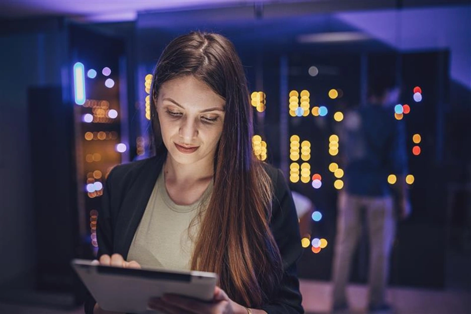 A woman with a laptop inside a data center