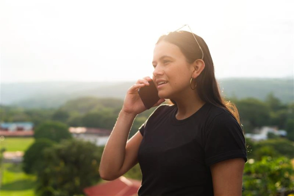 Mujer habla por celular en una zona aislada de costa rica