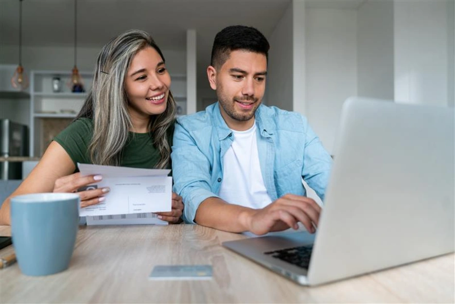 Happy couple paying bills online